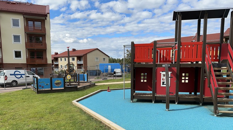 Bild på lekpark och nybyggt lägenhetshus.